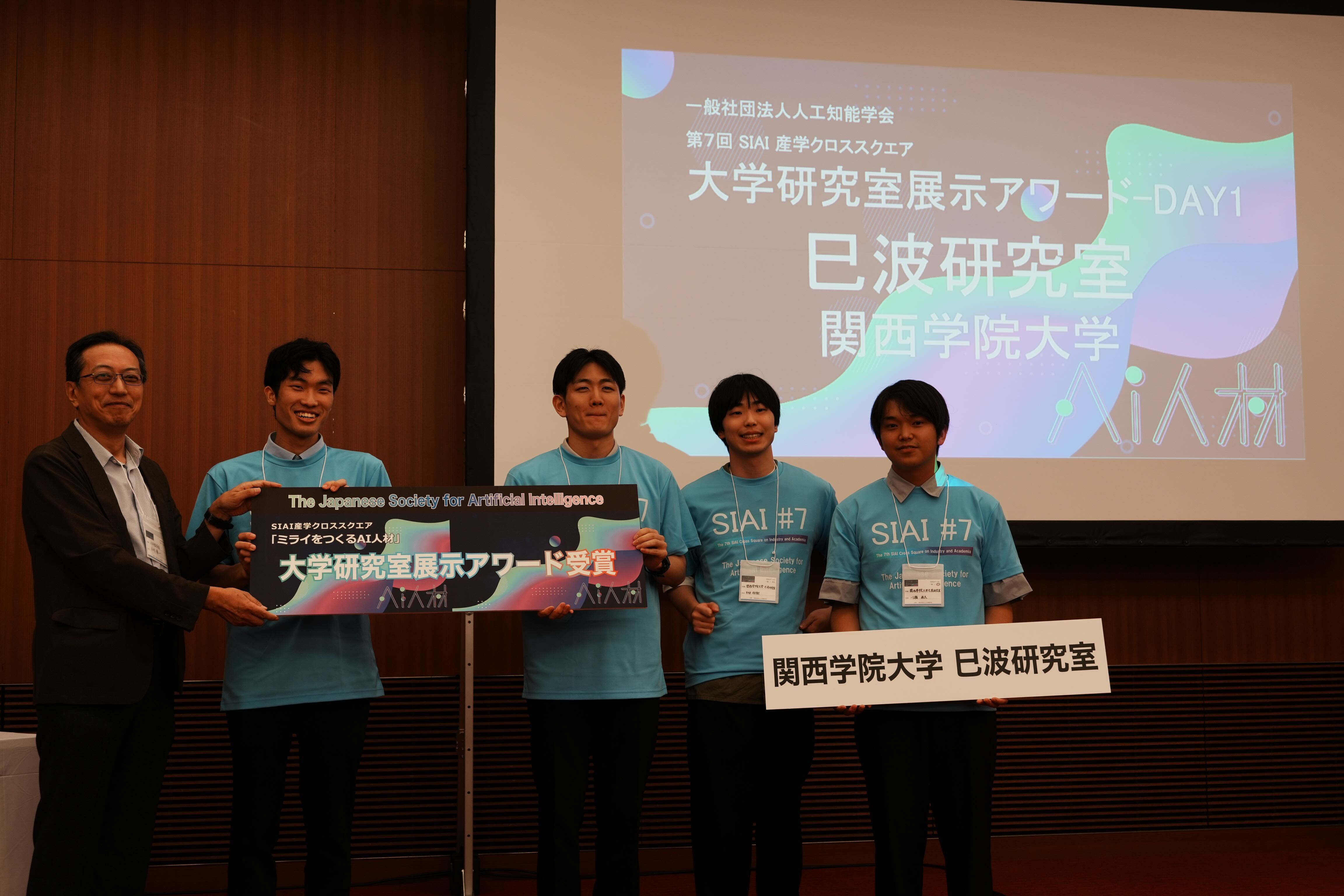 写真は右から川瀬佳太さん・杉本佳樹さん・橘憲正さん・杤尾総介さん・本村陽一人工知能学会副会長