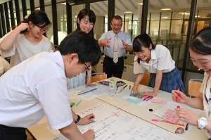 貧困や飢餓、医療支援、平等な教育などについて グループで話し合う高校生たち
