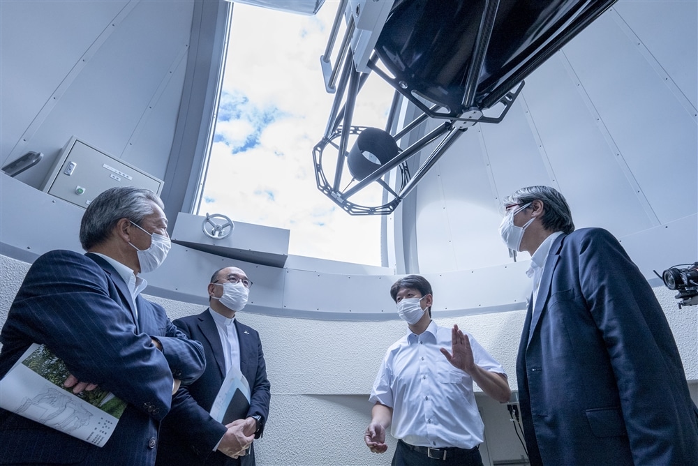 天体望遠鏡を説明する松浦周二教授・理学部物理宇宙学科(右から2人目)