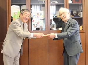 加藤千秋氏（右）から手紙を受け取る井上学長