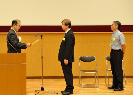 授賞式／奥野・大学図書館長（中央）と安本・大学図書館事務部長（右）