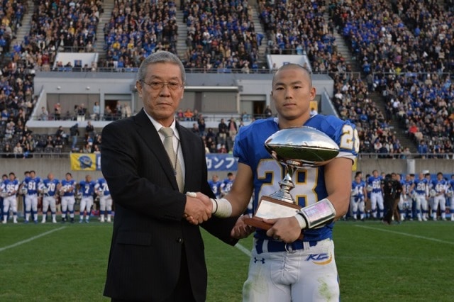伊角富三・関西学生アメリカンフットボール連盟理事長から優勝トロフィーを受け取る鷺野主将