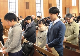 会場に集まり黙祷を捧げる学生・教職