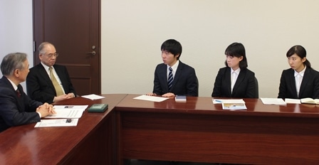 報告会で村田治学長（左）に報告する学生