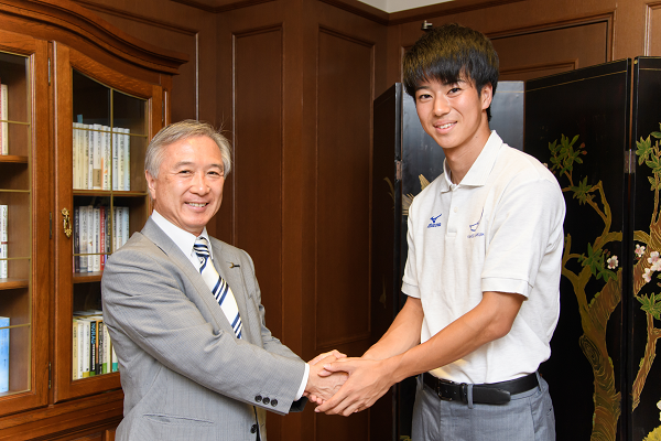 村田学長と握手する多田修平選手（法学部3年生）