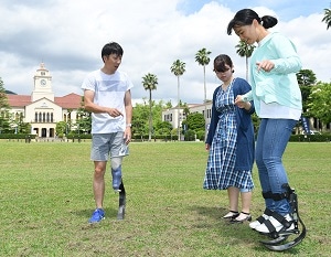 義足をはいた歩き方の指導を受ける学生たち