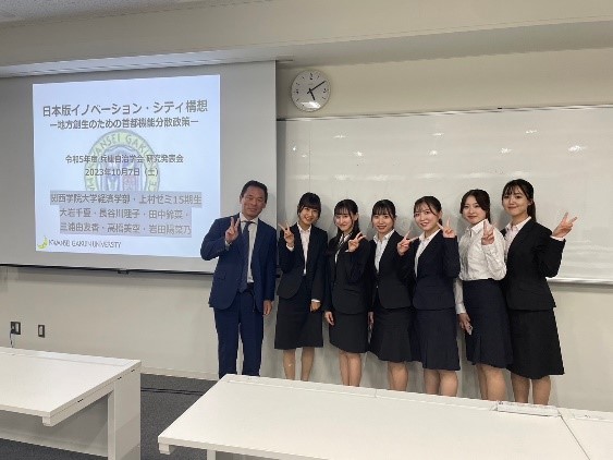 (研究発表を終えて集合写真。左は専門演習の指導教授である上村敏之・経済学部教授)