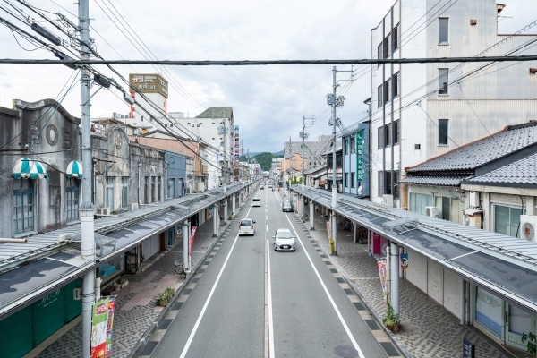 北但大震災からの復興で整備された豊岡の大開通り。左手には復興過程で建設された鉄筋コンクリート造の11軒長屋の防火建築帯がみえる.「写真：Tetsuya & Tomoyo Hayashiguchi」